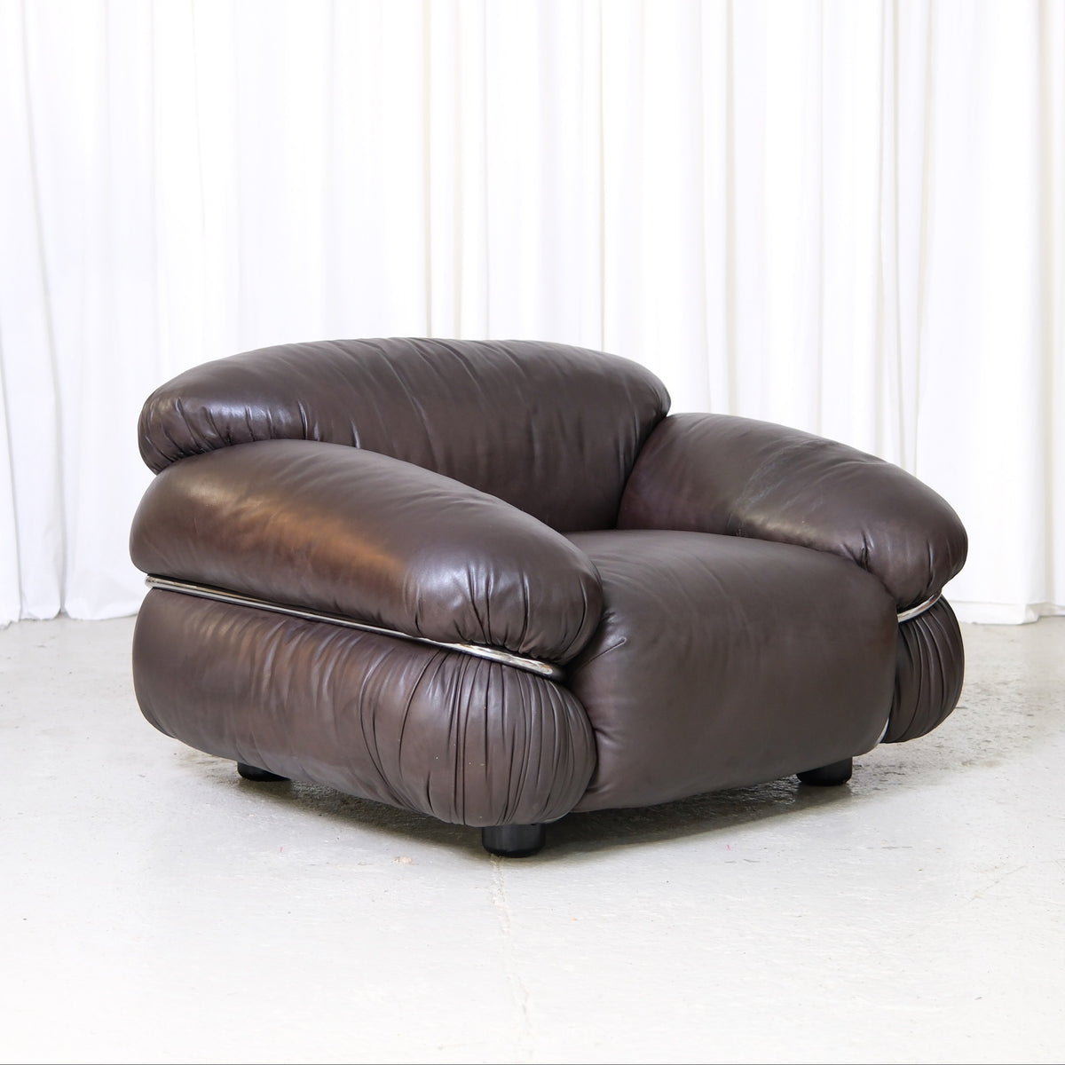 Gianfranco Frattini Sesann-fåtölj i original för Cassina i mörkbrunt läder. Italiensk designklassiker tillgänglig i Helsingfors med leverans över hela världen.
