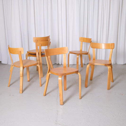 Set of vintage Alvar Aalto Chair 69 Sandwich chairs for Artek in natural birch with visible vintage patina photographed in studio.