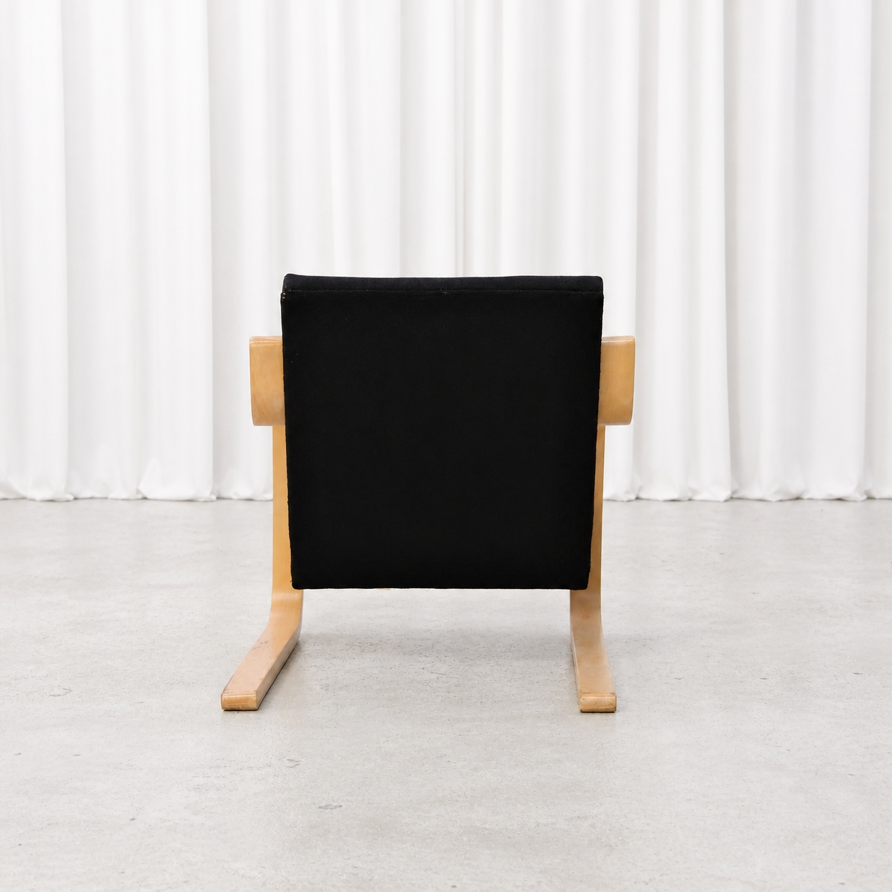 Rear view of a 1960s Artek 402 armchair with black fabric upholstery