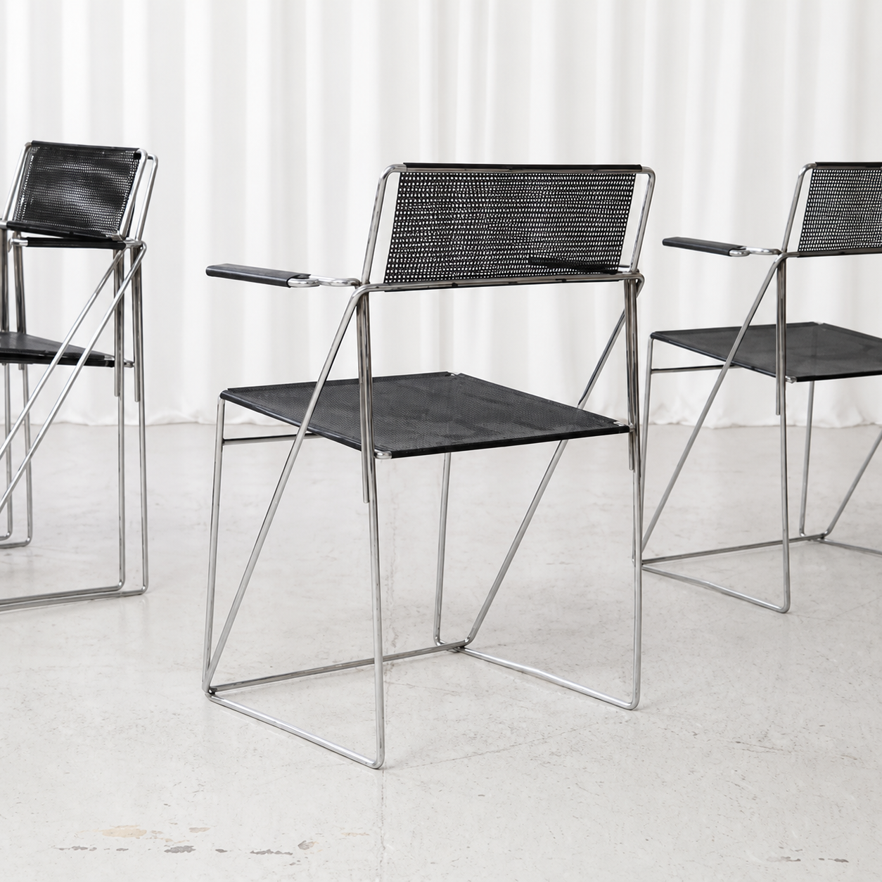 Black and chrome Hybodan X-Line armchair with perforated steel seat and back