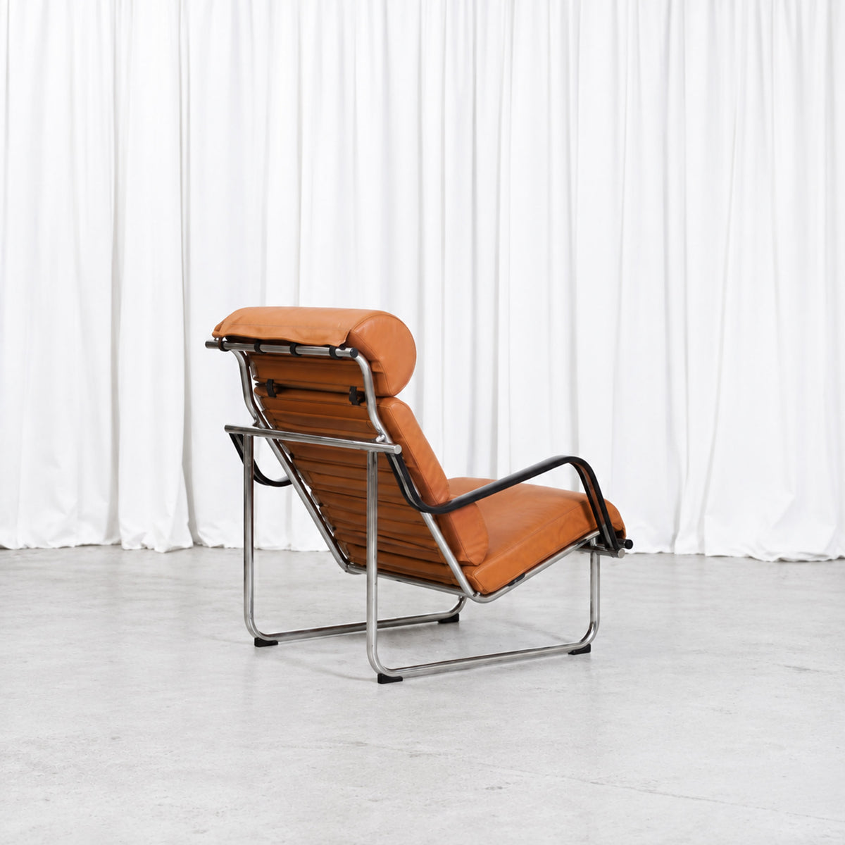 Yrjö Kukkapuro Remmi lounge chair in cognac leather, rear three-quarter view